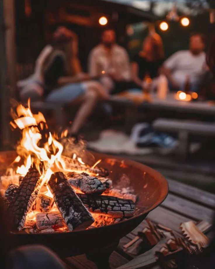 A small circle of founders around a firepit at dusk
